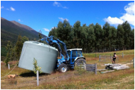 Tractor transports 30,000 litre water tank at Muntanui, South Island, New Zealand