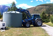 Tractor lifts 30,000 litre water tank at Muntanui biodynamic farm, South Island, New Zealand